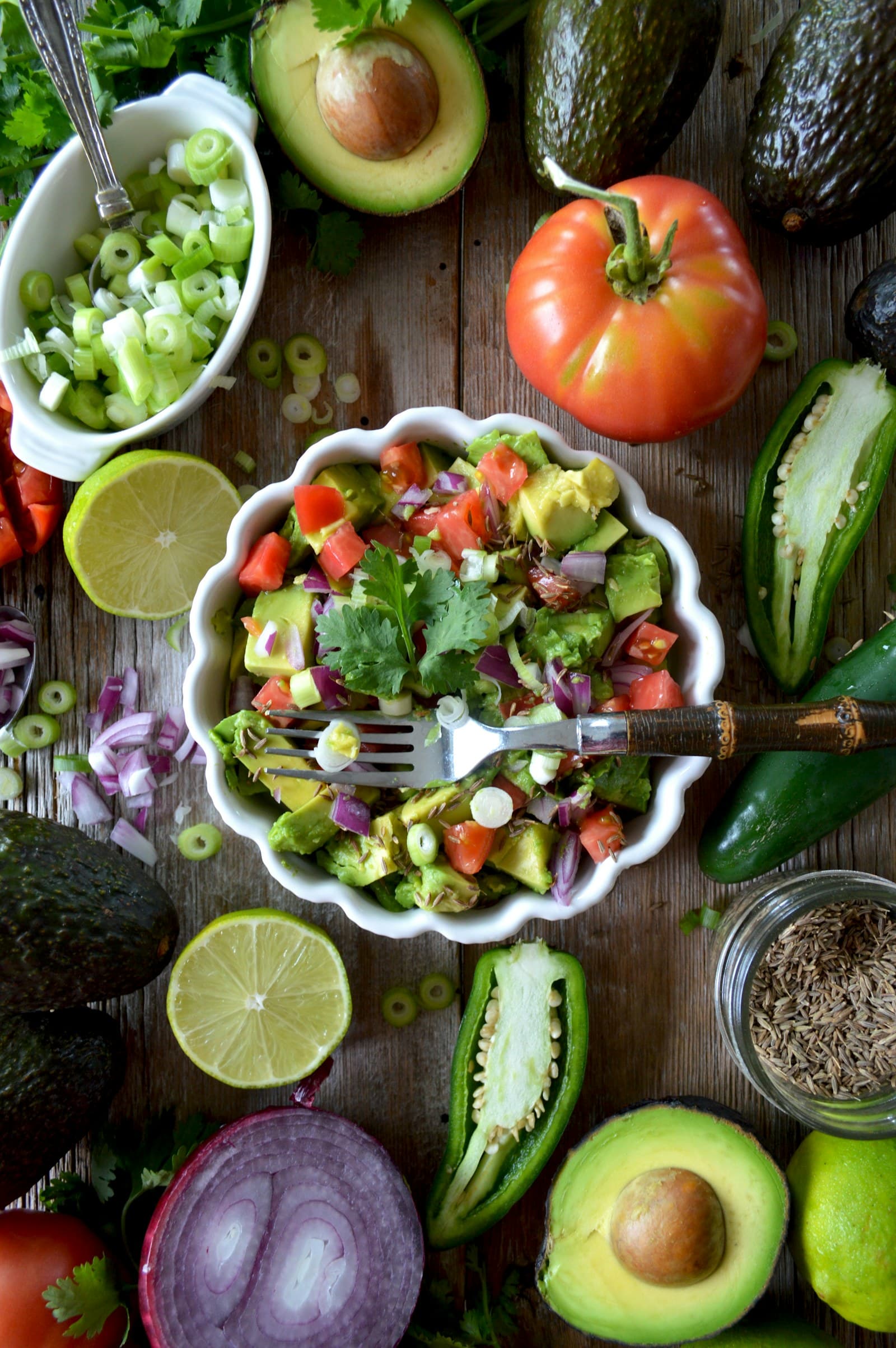 Ensalada de aguacate rodeada de aguacate, tomate, cebolla, lima y jalapeño